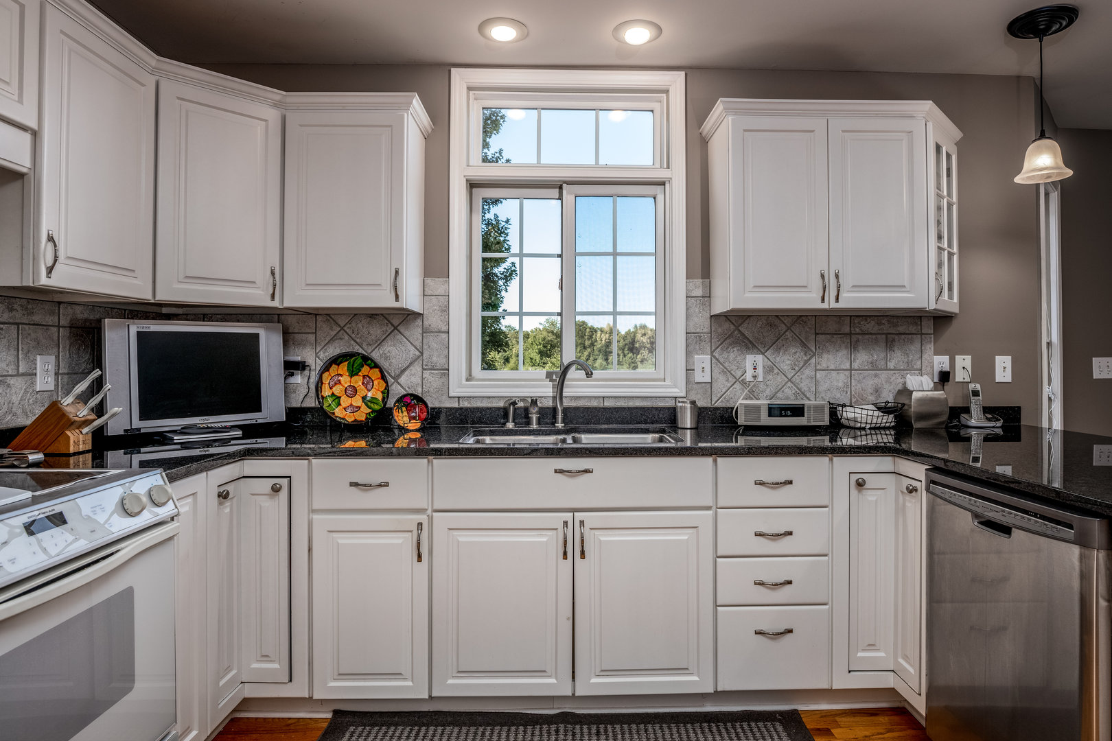 2656 East 1559th Road Ottawa, IL 61350 - Photo 23 of 49 a kitchen with granite countertop a stove a sink and white cabinets