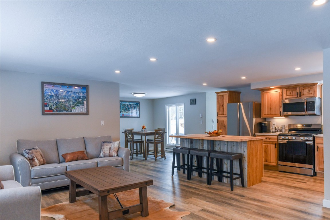 a living room with furniture a dining table and a wooden floor