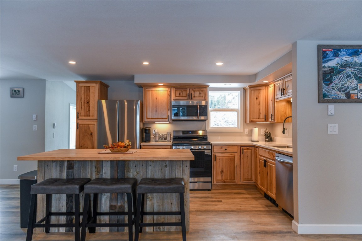452 Cascade Circle Silverthorne, CO 80498 - Photo 12 of 35 a kitchen with stainless steel appliances granite countertop a stove top oven a sink dishwasher and a refrigerator with wooden floor