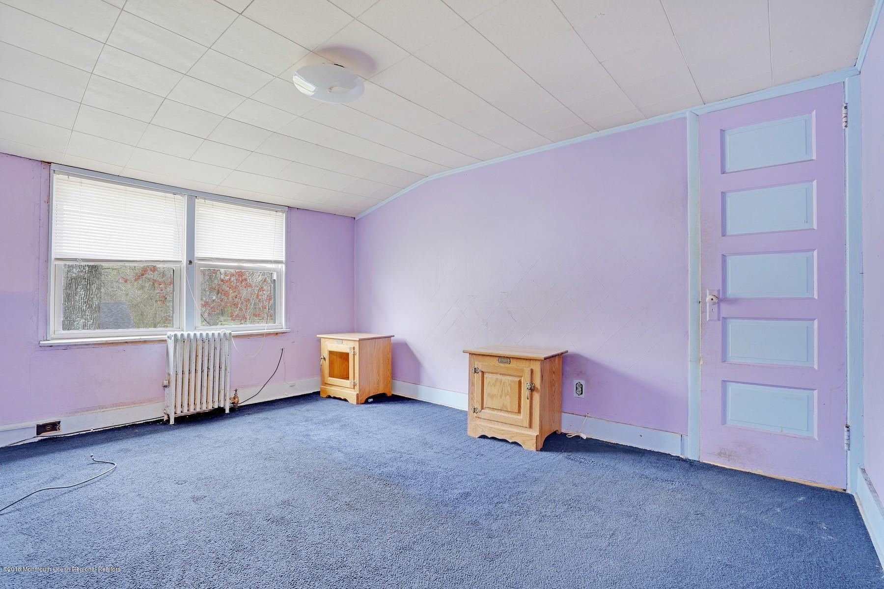 69 Old Tavern Road Howell, NJ 07731 - Photo 22 of 46 an empty room with a chair and window
