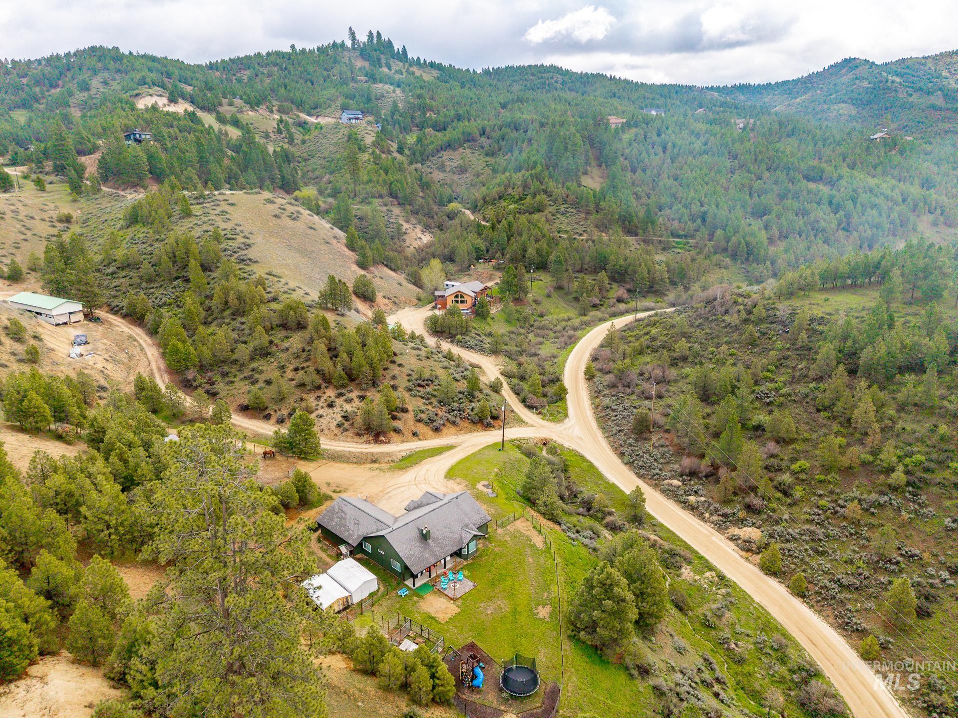 4 Round Up Circle Boise, ID 83716 - Photo 46 of 47 Expansive property with a green-sided residence, multiple outbuildings, and a gravel drive