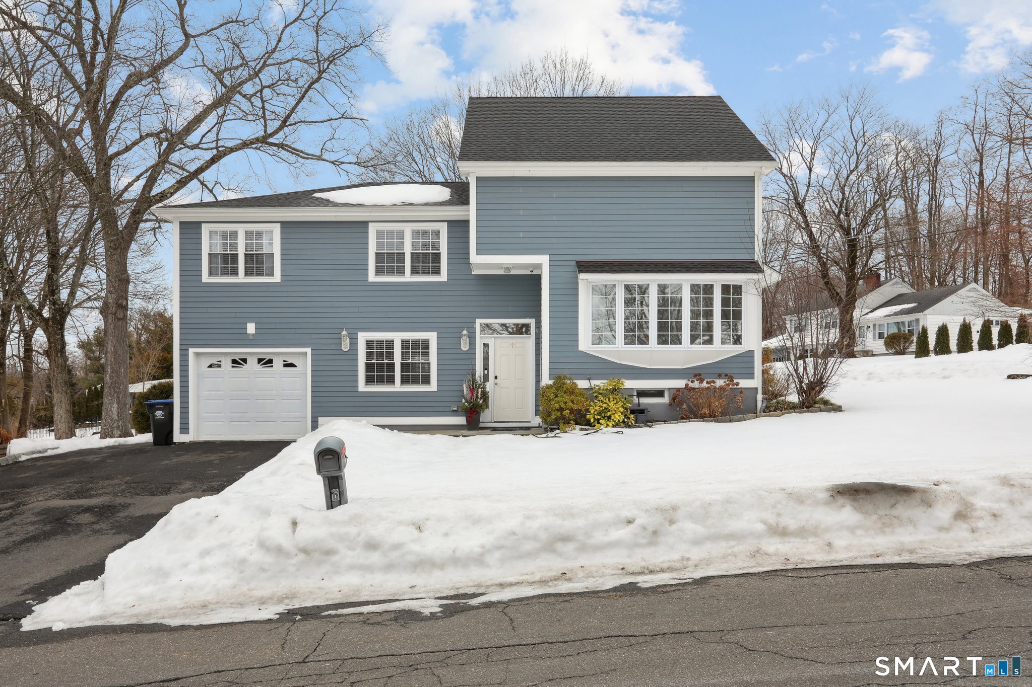 a front view of a house with a yard covered in snow