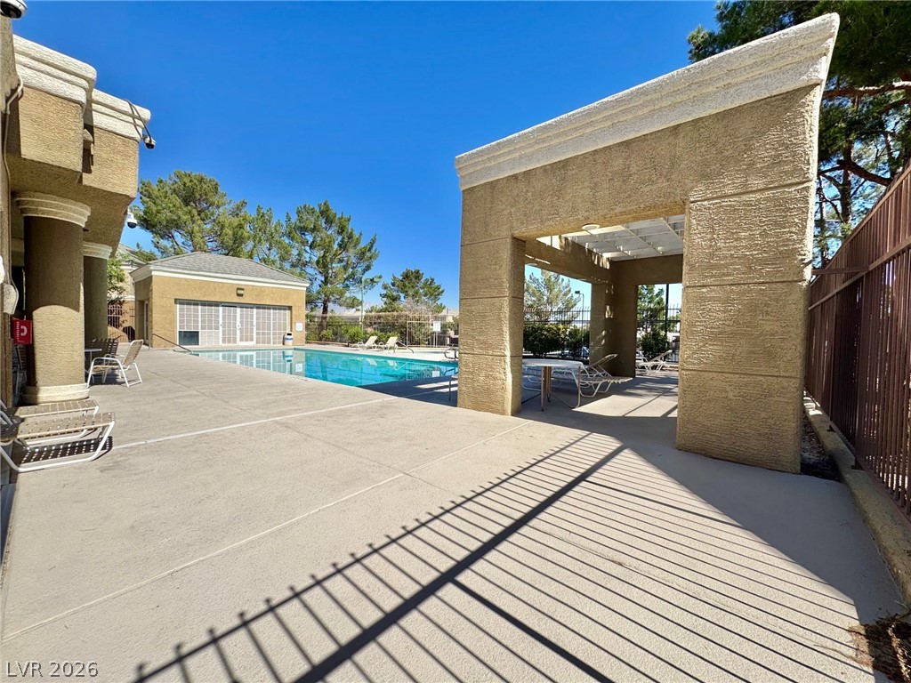 8070 West Russell Road, Unit 2121 Las Vegas, NV 89113 - Photo 22 of 22 An inviting pool area offers relaxation under the clear blue sky, perfect for leisure and outdoor enjoyment.