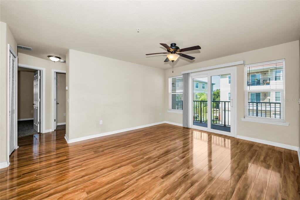 5064 Royal Palms Way, Unit 204 New Port Richey, FL 34652 - Photo 11 of 89 a view of empty room with wooden floor and fan