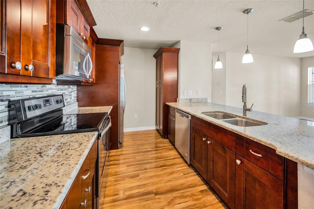 5064 Royal Palms Way, Unit 204 New Port Richey, FL 34652 - Photo 14 of 89 a large kitchen with stainless steel appliances granite countertop a sink and a stove