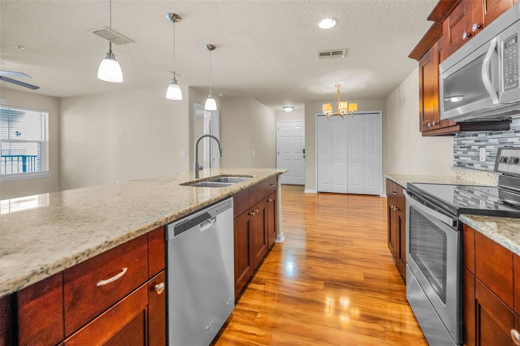 5064 Royal Palms Way, Unit 204 New Port Richey, FL 34652 - Photo 8 of 89 a kitchen with stainless steel appliances granite countertop a sink a stove top oven a counter space and cabinets
