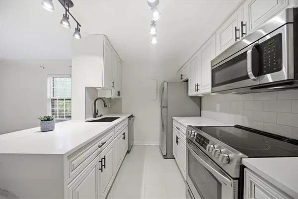 a kitchen that has a sink and a stove top oven