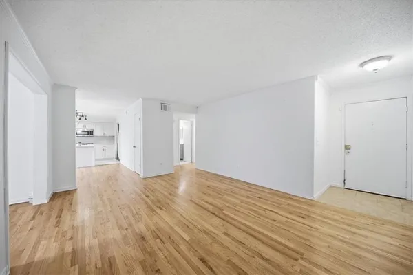 a view of an empty room with wooden floor