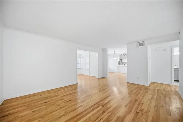 a kitchen with granite countertop white cabinets a sink dishwasher and a stove with wooden floor