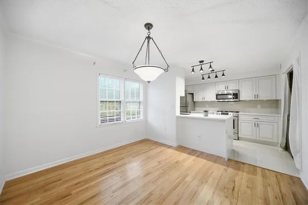 a kitchen with stainless steel appliances a sink a stove a microwave and cabinets