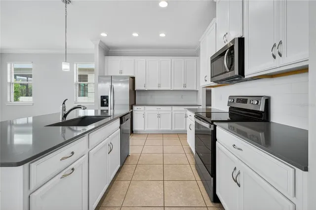 a kitchen with white cabinets and refrigerator