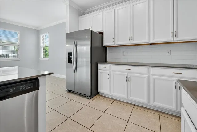 a kitchen with white cabinets and stainless steel appliances