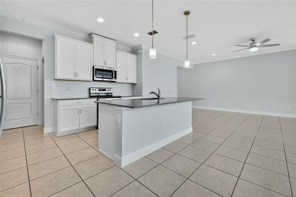 6687 Alder Road Harmony, FL 34773 - Photo 14 of 42 a kitchen with a sink a counter top space cabinets and stainless steel appliances
