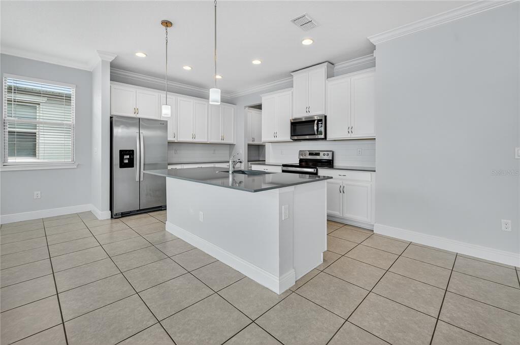 6687 Alder Road Harmony, FL 34773 - Photo 15 of 42 a kitchen with stainless steel appliances a refrigerator sink and microwave