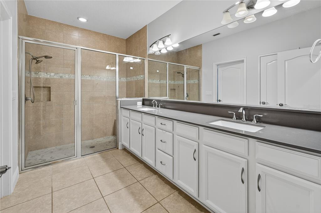 6687 Alder Road Harmony, FL 34773 - Photo 22 of 42 a spacious bathroom with a shower sink and mirror