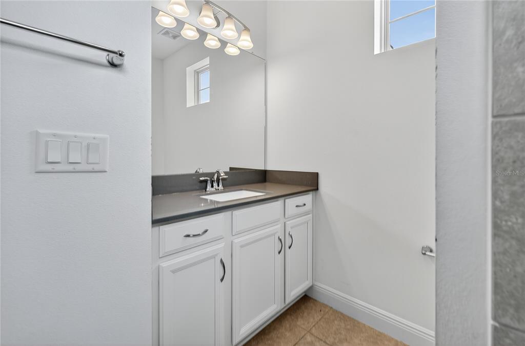 6687 Alder Road Harmony, FL 34773 - Photo 36 of 42 a bathroom with a sink vanity and a mirror