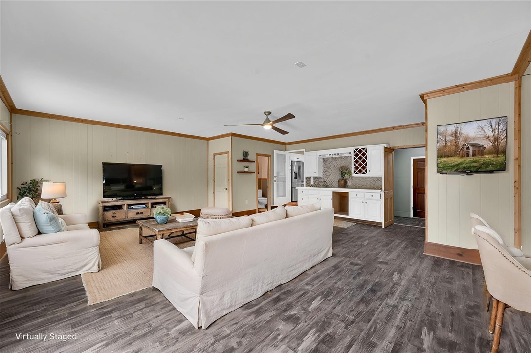433 Latham Road Easley, SC 29640 - Photo 50 of 50 An open floorplan living area features resilient vinyl flooring, a modern ceiling fan, and abundant natural light.