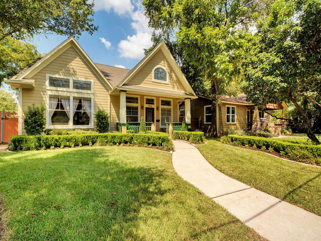 a front view of a house with yard and green space