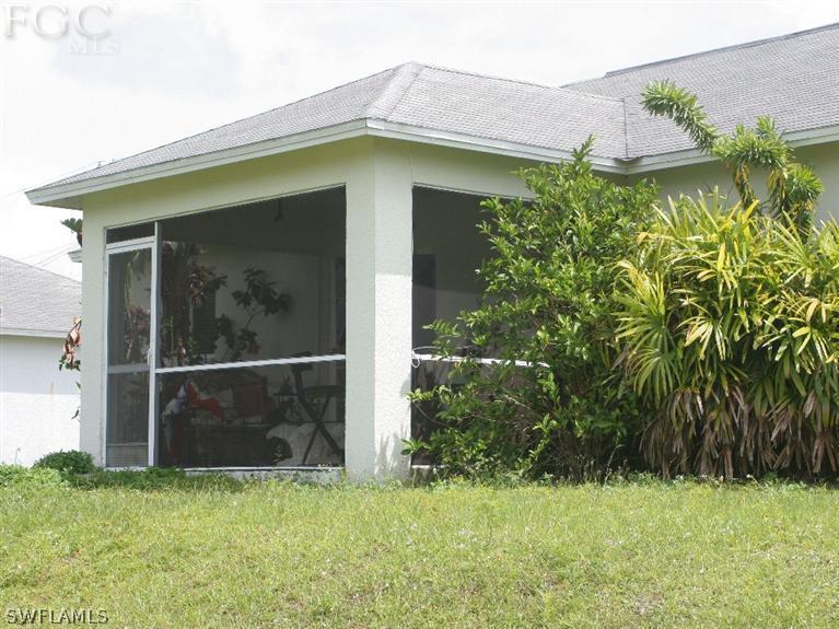 213 Rue Labonne Road Fort Myers, FL 33913 - Photo 7 of 8 a yellow house with tree in front of it