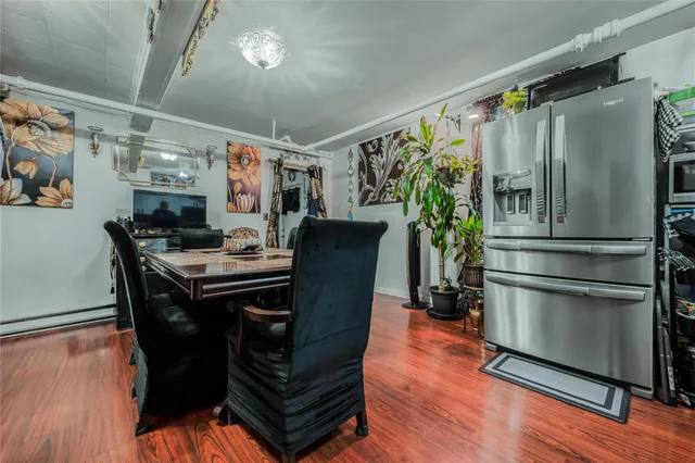 a kitchen with stainless steel appliances granite countertop a refrigerator a stove and a dining table with wooden floor