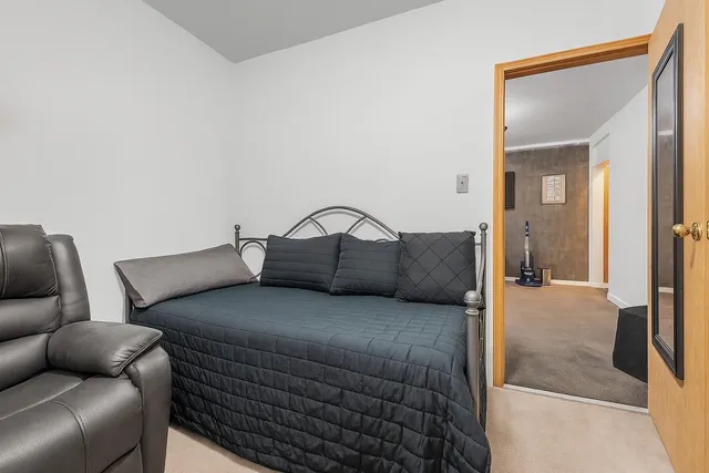 a bedroom with a bed couch and a mirror