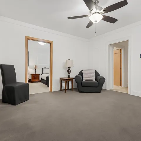 a living room with furniture and a ceiling fan