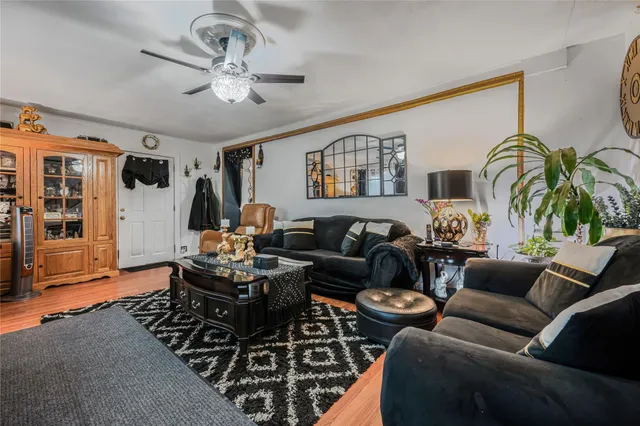 a living room with furniture a ceiling fan and a rug