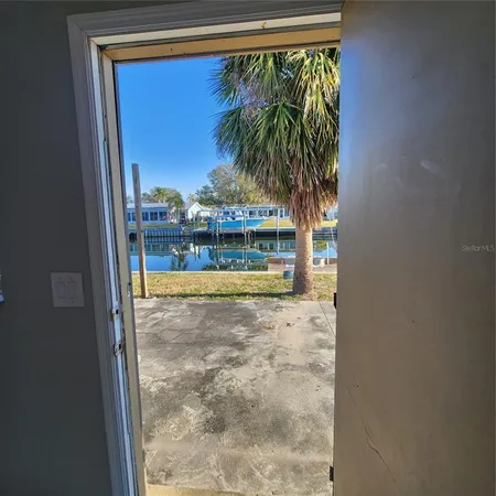 a view of a room with wooden floor and a refrigerator