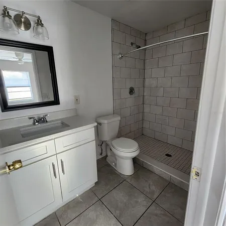 a bathroom with a toilet sink vanity and mirror