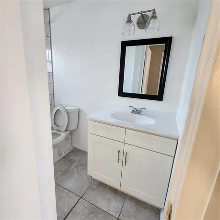 a bathroom with a toilet sink vanity and mirror