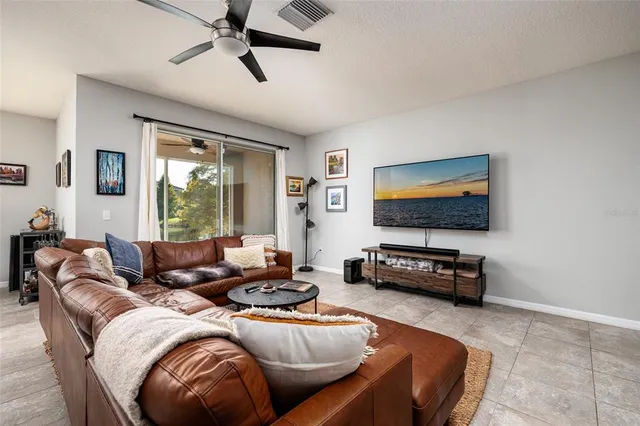 a living room with a floor to ceiling window and wooden floor