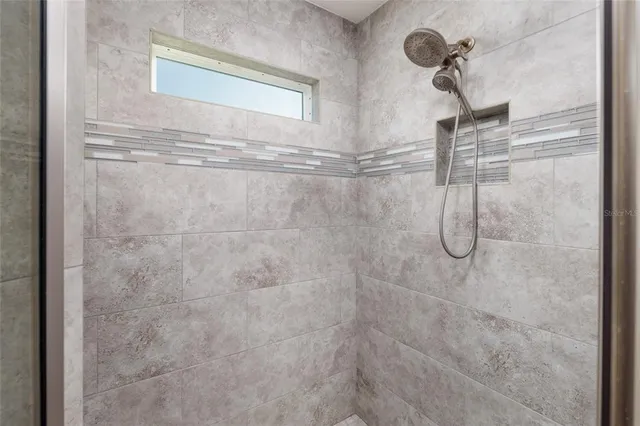 a bedroom with a bed a desk and chair with the bookshelf