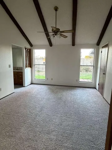 a view of a livingroom with a ceiling fan and window