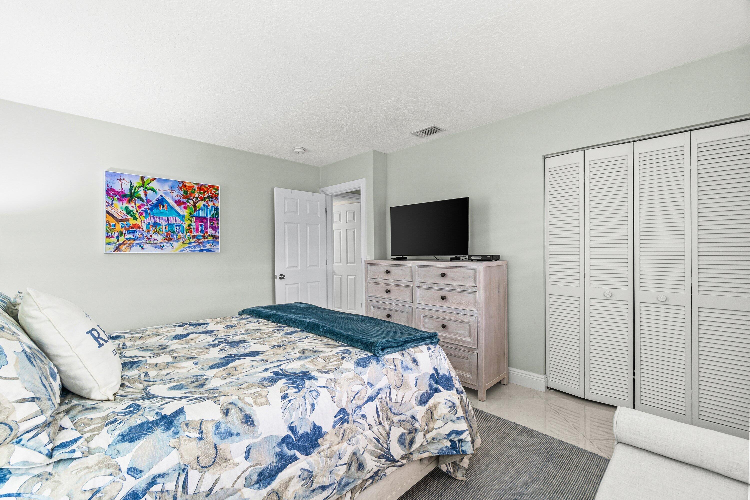 24 Stratford Drive East, Unit D Boynton Beach, FL 33436 - Photo 15 of 52 a bedroom with a bed and a flat screen tv