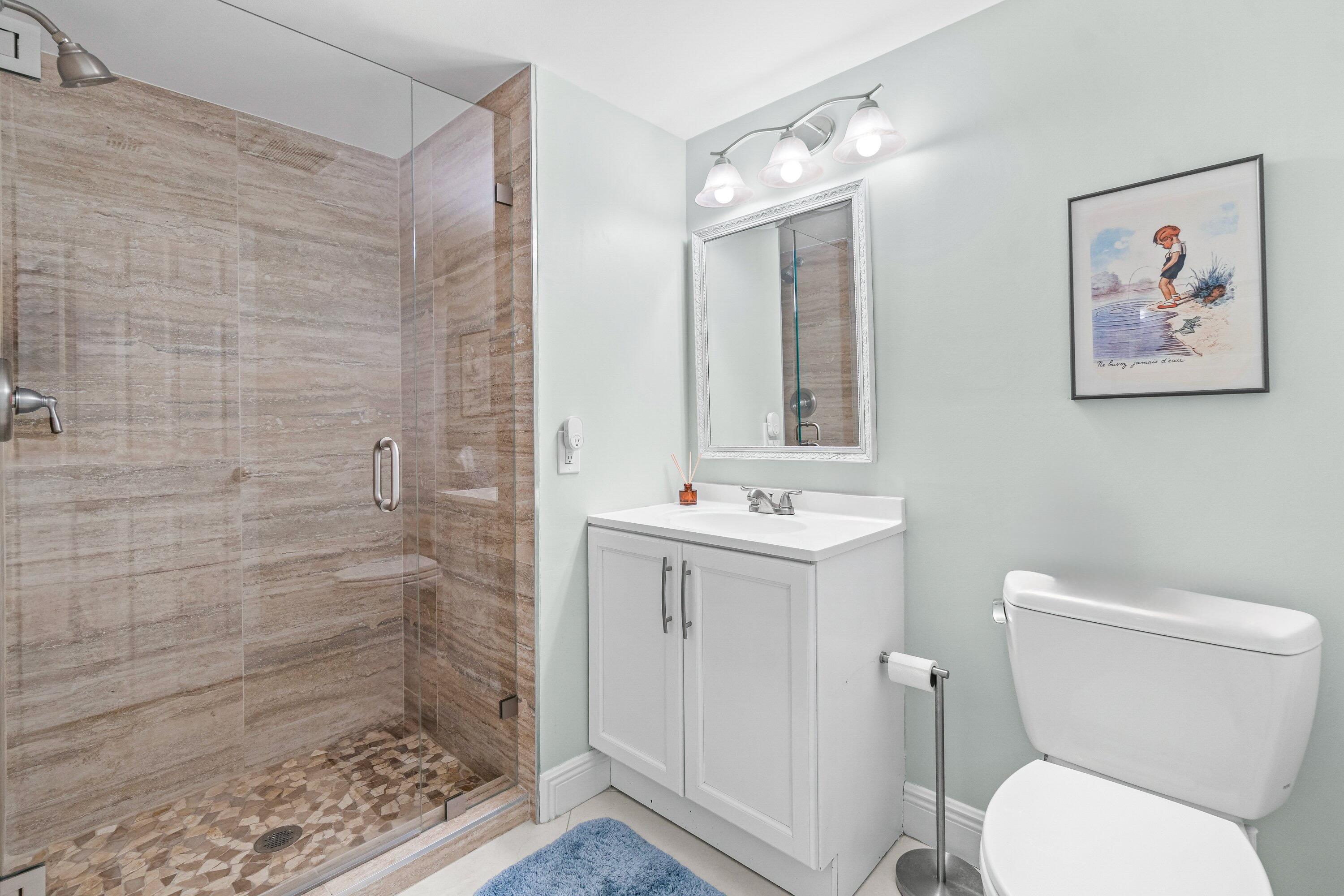 24 Stratford Drive East, Unit D Boynton Beach, FL 33436 - Photo 16 of 52 a bathroom with a toilet sink and mirror