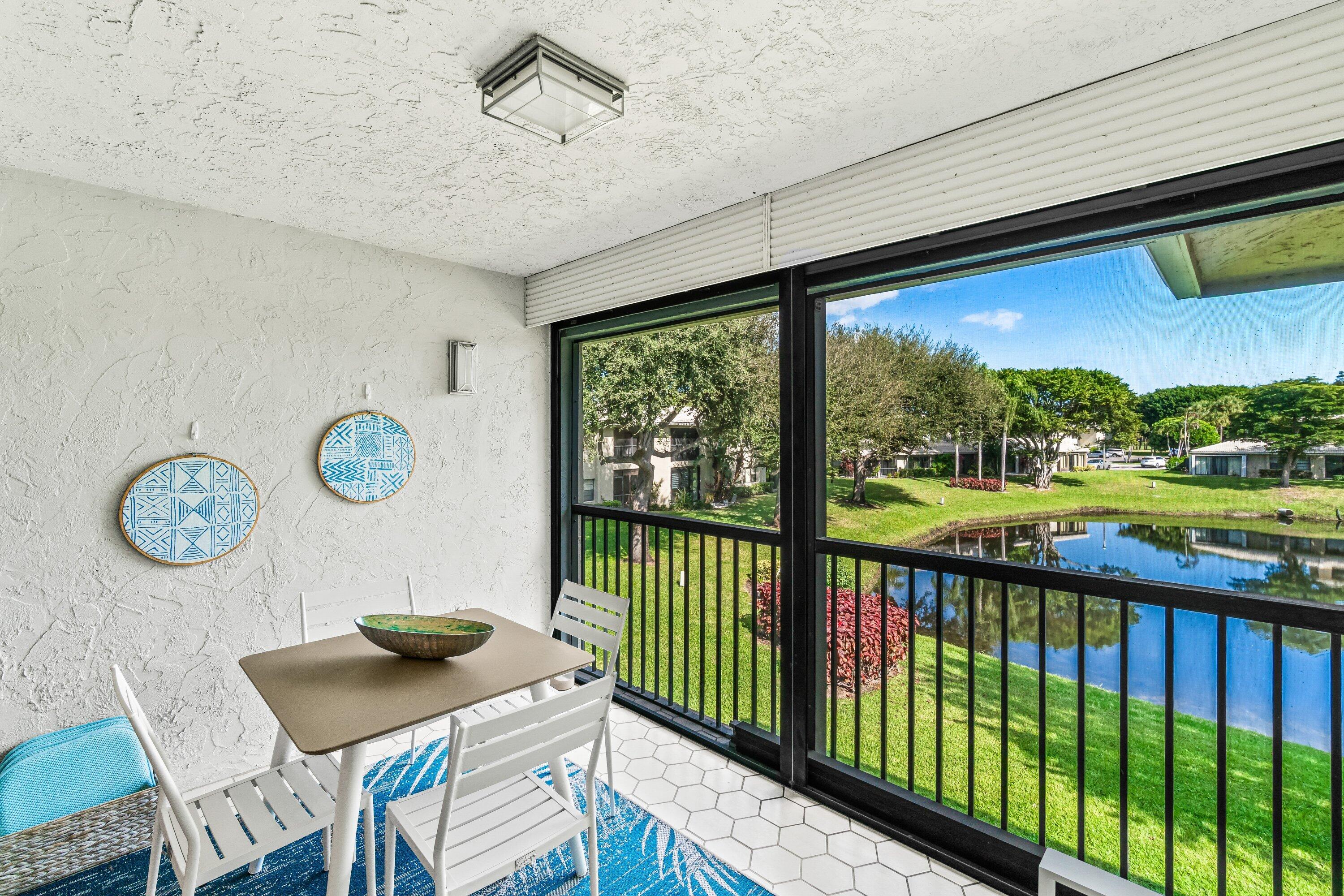 24 Stratford Drive East, Unit D Boynton Beach, FL 33436 - Photo 25 of 52 a view of a chairs and table in a patio