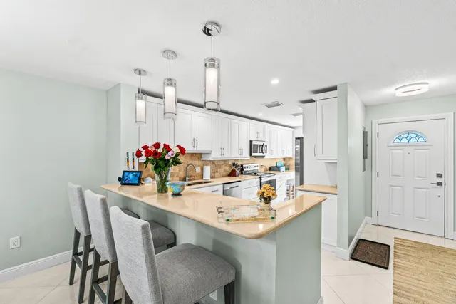 a kitchen with kitchen island granite countertop stainless steel appliances sink and cabinets