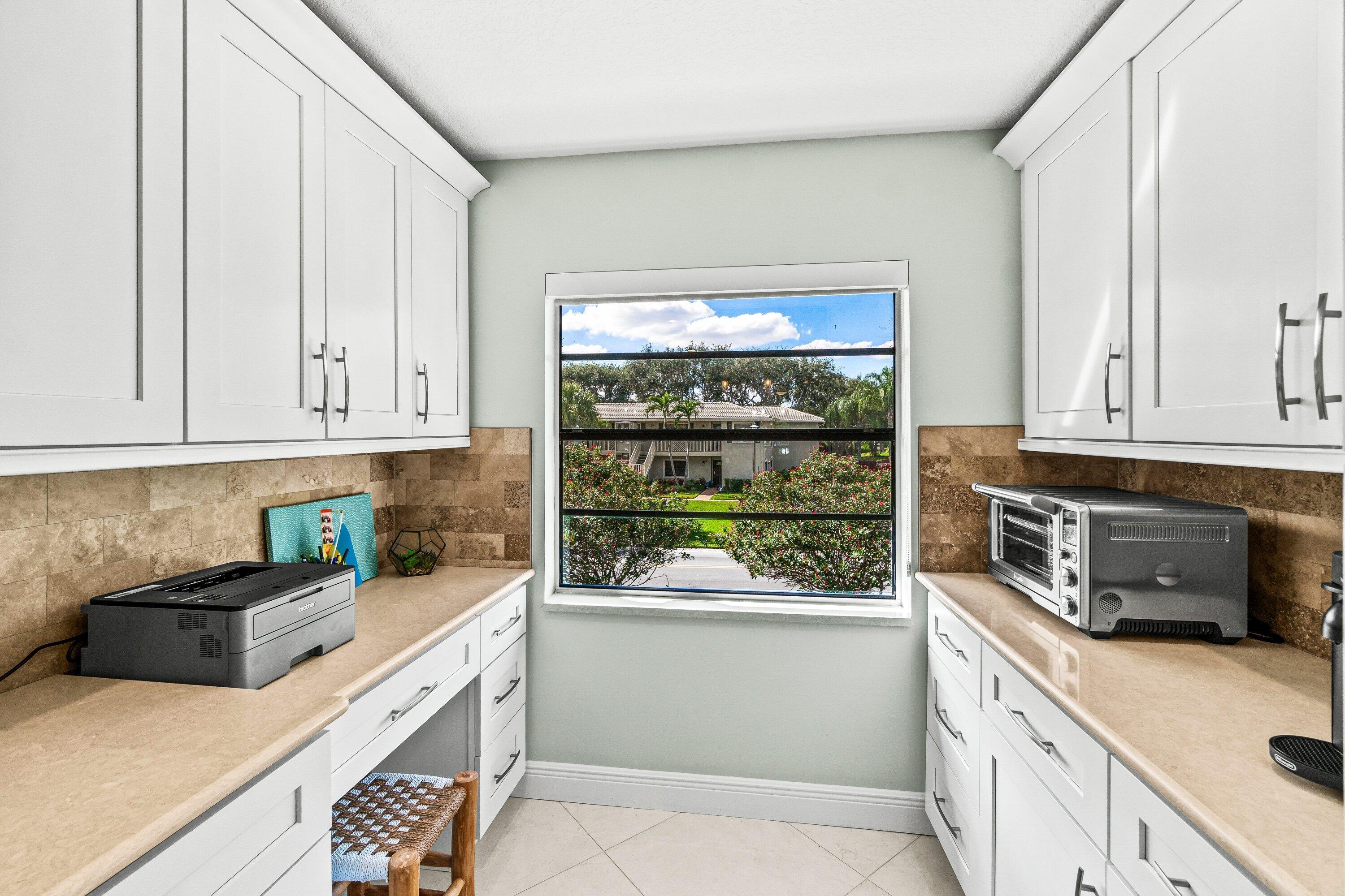 24 Stratford Drive East, Unit D Boynton Beach, FL 33436 - Photo 10 of 52 a kitchen with stainless steel appliances white cabinets and a window