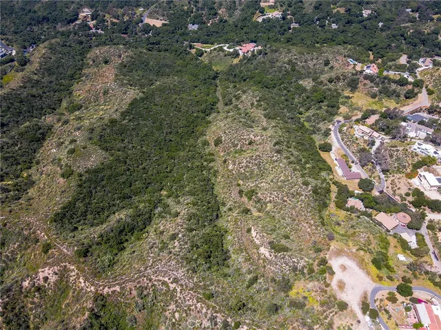 a view of a lush green field with mountains in the background