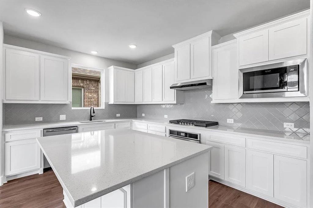 6246 Shasta Creek Road Celina, TX 75009 - Photo 9 of 24 a kitchen with cabinets appliances a sink and a counter top space
