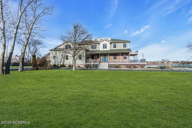 a view of a house with a big yard and large trees