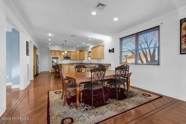 a kitchen with stainless steel appliances granite countertop wooden floors stove and white cabinets