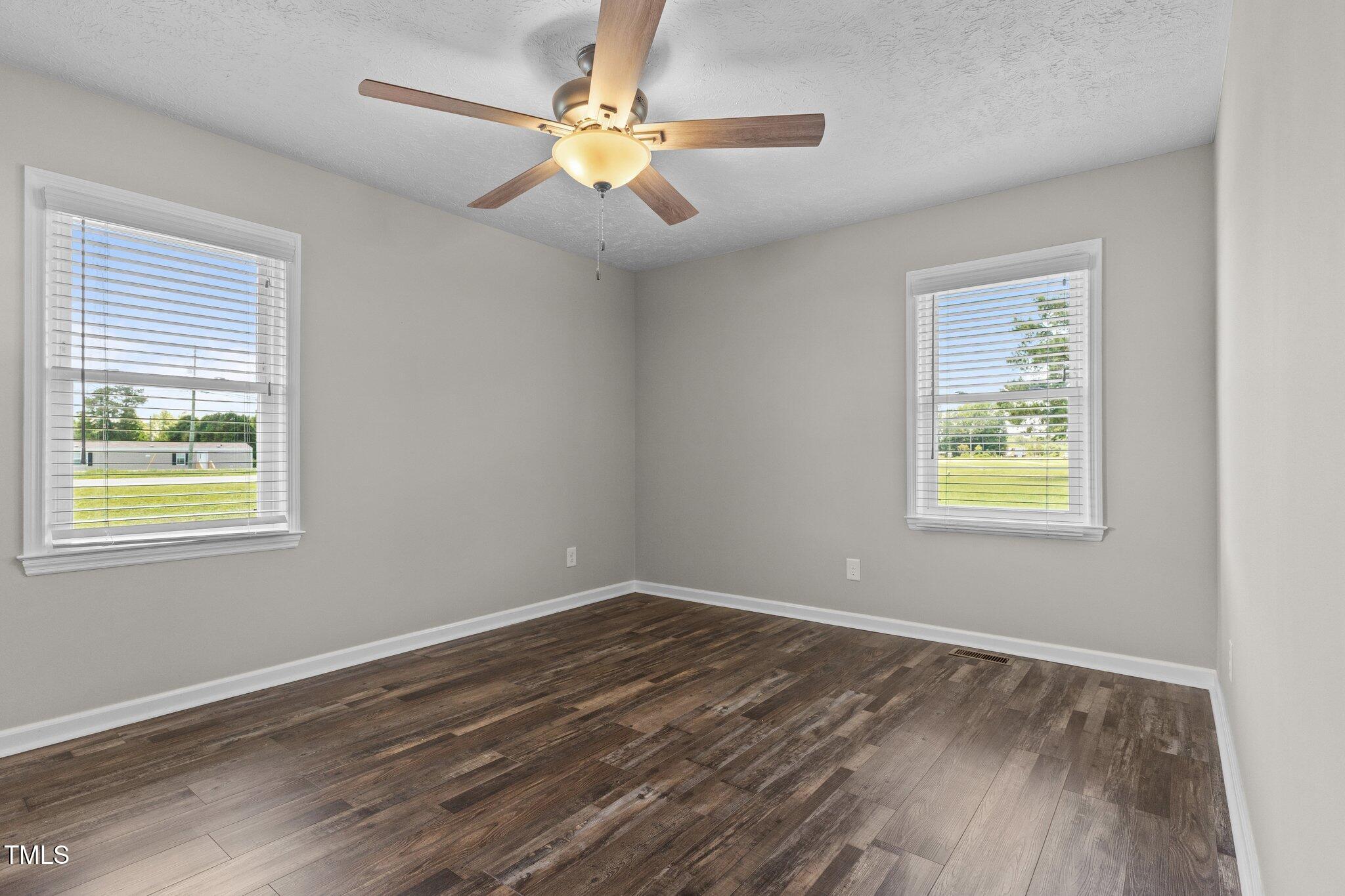 8431 Clinton Road Stedman, NC 28391 - Photo 16 of 24 a view of an empty room with wooden floor and a window