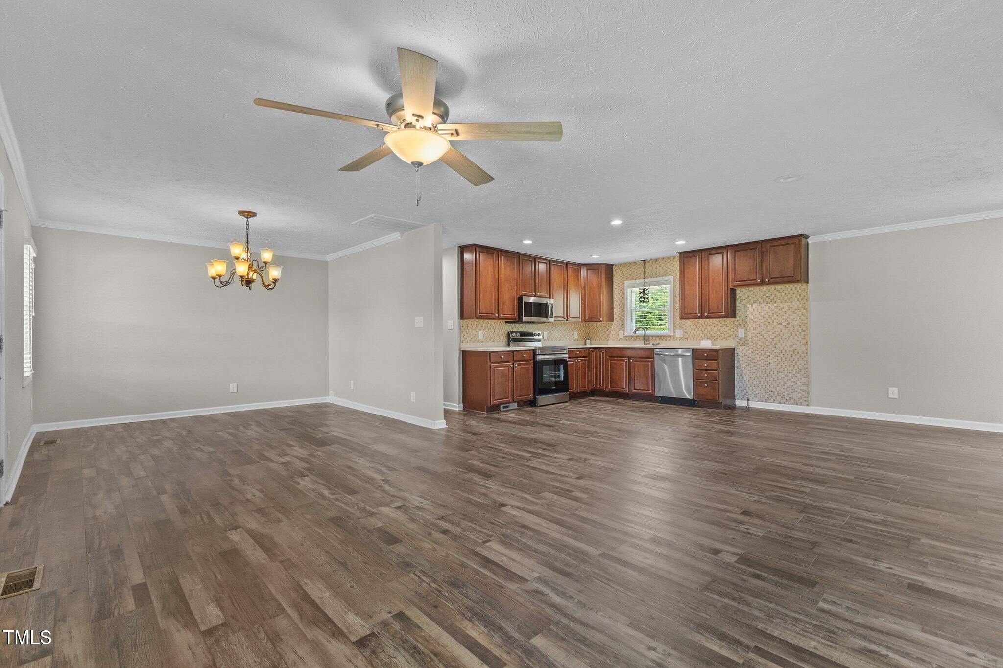 8431 Clinton Road Stedman, NC 28391 - Photo 2 of 24 a view of a kitchen with a microwave and wooden floor