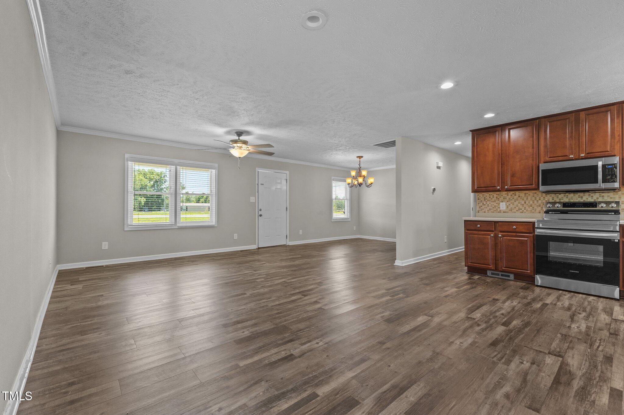 8431 Clinton Road Stedman, NC 28391 - Photo 3 of 24 a view of an empty room with a window and wooden floor