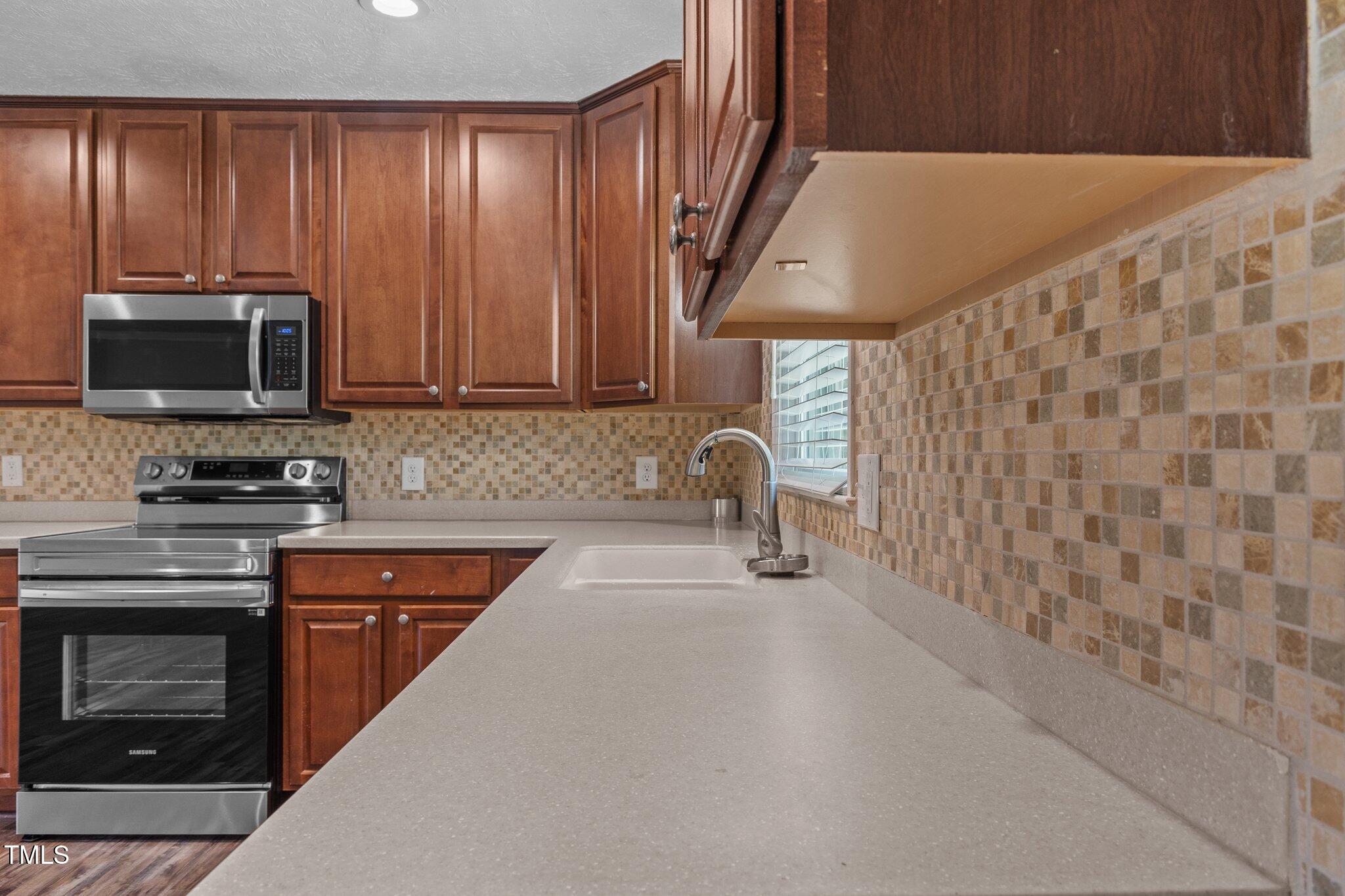 8431 Clinton Road Stedman, NC 28391 - Photo 4 of 24 a kitchen with a sink a stove and cabinets