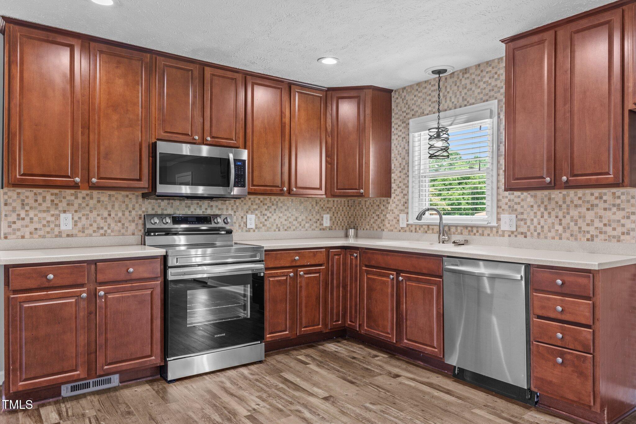 8431 Clinton Road Stedman, NC 28391 - Photo 5 of 24 a kitchen with stainless steel appliances granite countertop wooden cabinets a sink and a stove