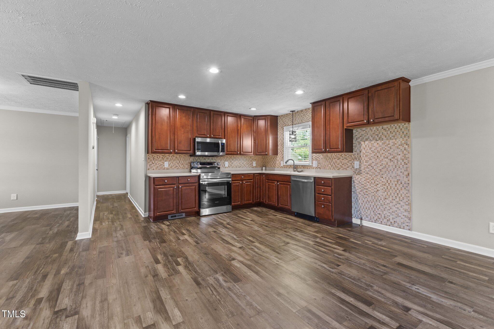 8431 Clinton Road Stedman, NC 28391 - Photo 6 of 24 a kitchen with stainless steel appliances granite countertop a stove sink and cabinets