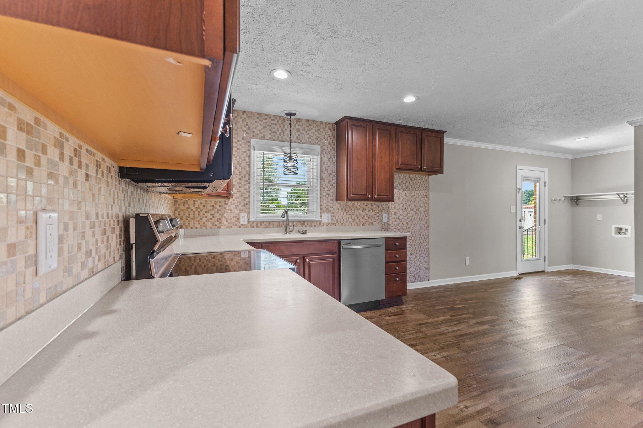 8431 Clinton Road Stedman, NC 28391 - Photo 7 of 24 a large kitchen with stainless steel appliances kitchen island granite countertop a sink a stove a microwave a counter top and cabinets