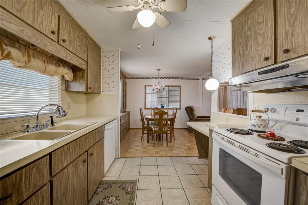 5619 Bayshore Road, Unit 312 Palmetto, FL 34221 - Photo 17 of 40 a kitchen with a sink a stove and chairs